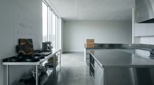 Cuisine professionnelle moderne avec équipements en acier inoxydable et espace de travail épuré